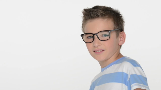 Kid of ten years, wears glasses, looks at the camera