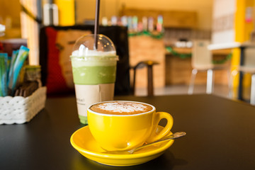 yellow cup of coffee on cafe table