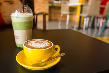 yellow cup of coffee on cafe table
