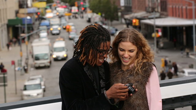 Young couple taking photo together in city