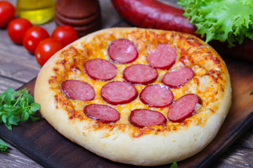 Hot Homemade Pepperoni Pizza on a wooden background with vegetables Ready to Eat