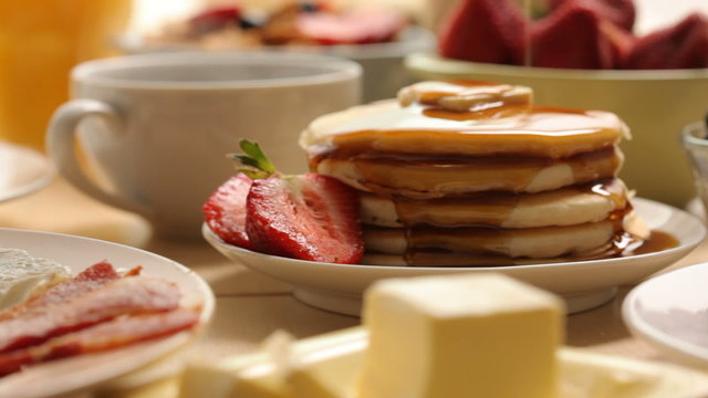 Pouring syrup on pancakes