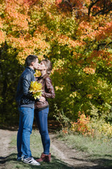 Fototapeta premium young couple in love, kiss, autumn vivid landscape