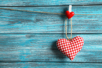Love heart hanging on rope on a blue wooden background