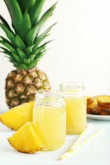 Fototapeta na wymiar Bottles of pineapple juice on a white wooden table