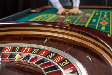 Obraz premium Roulette and piles of gambling chips on a green table. 