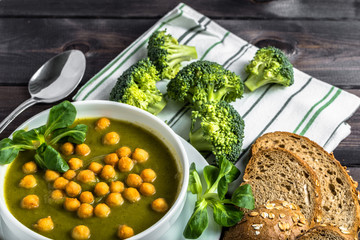 Italian broccoli soup or cream soup on wooden table.