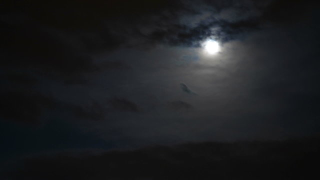 Full moon surrounded by clouds time lapse