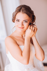 Naklejka premium beautiful brunette stylish bride getting ready in the morning in the room