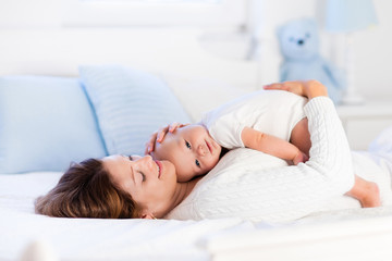 Obraz na płótnie Canvas Mother and baby on a white bed
