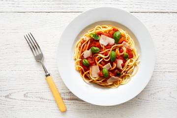 Spaghetti with tomato sauce, fresh basil and cheese. With fork s