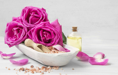 Obraz na płótnie Canvas Spa setting with roses, bath salt and oil
