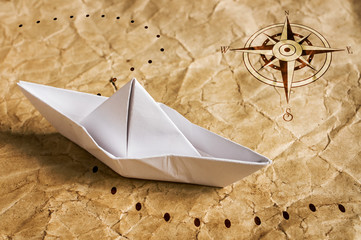 Paper boat on the old map