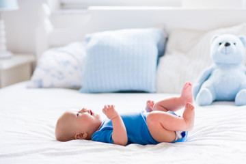 Fototapeta na wymiar Baby boy in white sunny bedroom