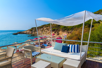 Sofa with table and chair on beach in Proteas bay, Samos island, Greece