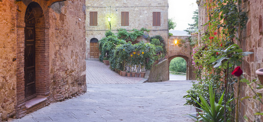 Fototapeta na wymiar walls and lonely street early in the morning in tuscany city in Italy