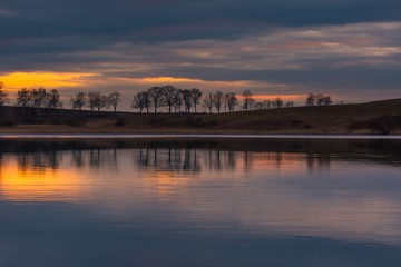 Fototapeta premium Close up of opposite shore of lake after sunset