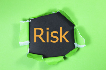 Risk word written under green torn paper