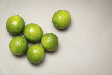 Six Bright Green limes on a blue plate