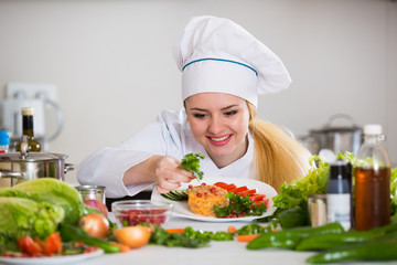 Happy cook preparing vegetable salad with cheese