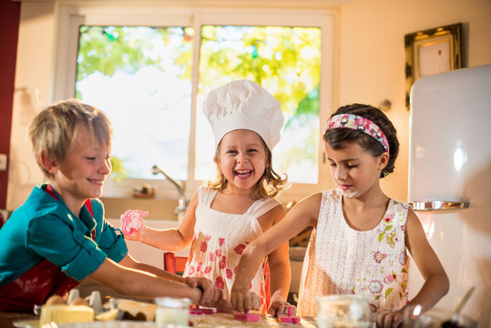 Three Brother And Sisters Are Cooking Together In The Kitchen