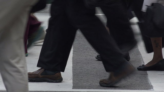 Close up of legs and feet of people crossing road