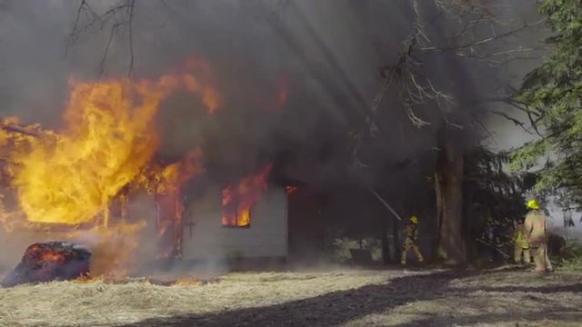 Firefighters battle huge flames coming from a house 