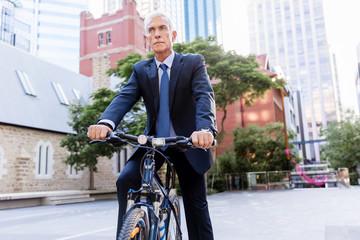 Successful businessman riding bicycle