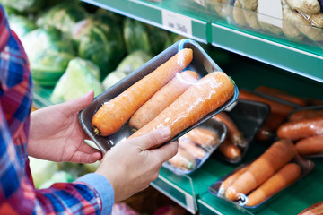 Buyer selects carrot in store