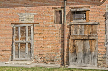 Two Old, Rustic Doors on an old brick building