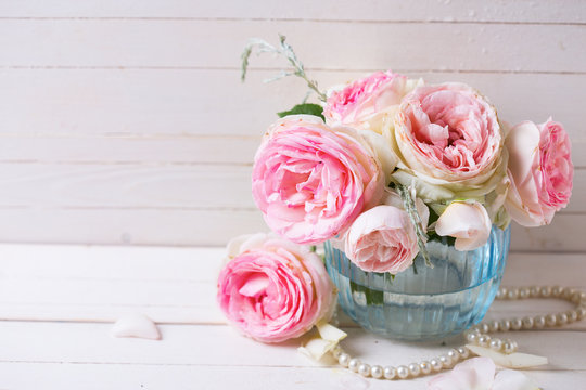 Sweet pink roses flowers  in blue vase on white painted wooden p