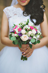 Bride is holding beautiful bright wedding bouquet