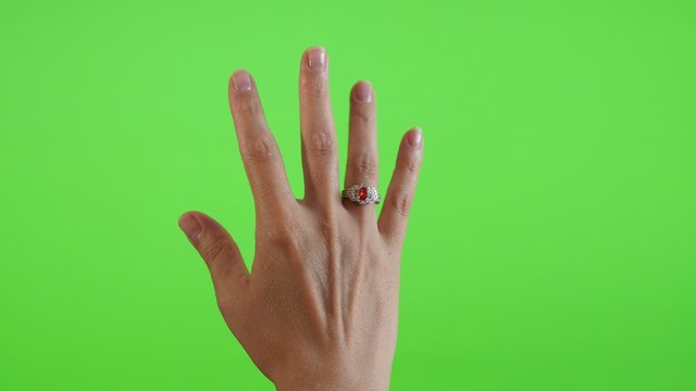 Trying son finger silver ring greenscreen display 4K 2160p UltraHD footage - Woman holding a ring and trying on green screen display 4K 3840X2160 UHD video 