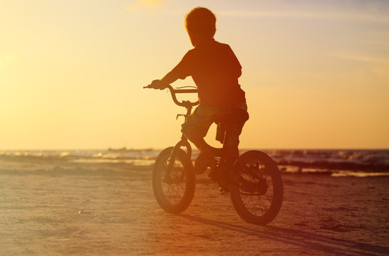 little boy riding bike at sunset © nadezhda1906