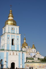 Fototapeta na wymiar White Blue Saint Michael's Orthodox Christian Cathedral with Multiple Golden Cupolas, Crosses and Sky in Kiev, Ukraine, Vertical