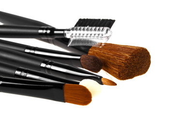 Fototapeta premium Bunch of make-up brushes lying randomly on white background