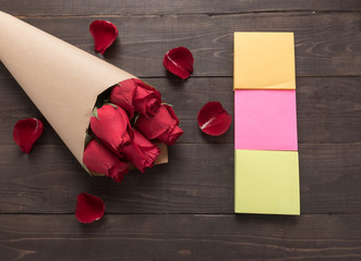 The arrangement of red roses flower with sticky notes are on the