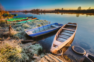 Fototapeta na wymiar River and old wooden rowing fishing boat at beautiful sunrise in