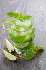 Fresh mojito cocktail with lime and mint on wooden table