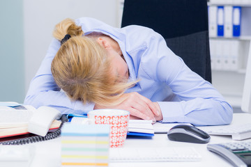 gestresste frau schläft am arbeitsplatz