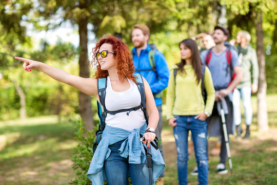 Girl in group of hikers pointing something.