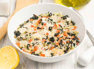 bowl with rice and dried seaweed before being cooked