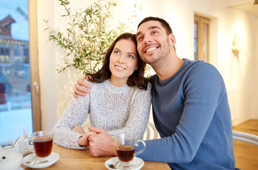 happy couple drinking tea at restaurant