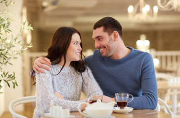 happy couple drinking tea at restaurant