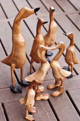 Seven hand made wooden ducks on wood background