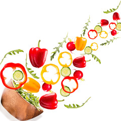 Falling salad in a wooden salad bowl. Vegetable isolated on white backgroud. Fresh pepper