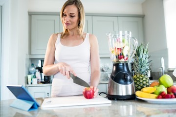 Pretty blonde woman preparing a smoothie