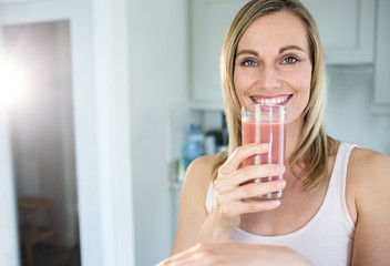 Pretty blonde woman holding her homemade smoothie