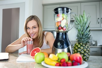 Pretty blonde woman holding her homemade smoothie