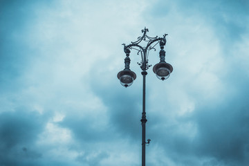 Old iron street light made of two lamps on a pole